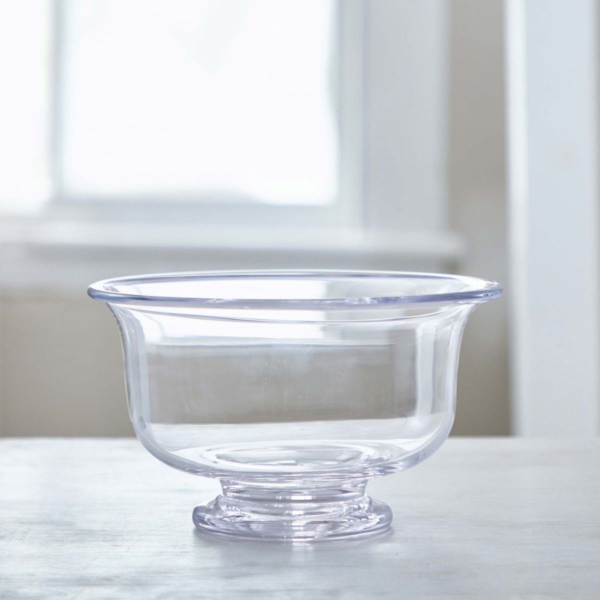 Medium clear Simon Pearce glass bowl with a footed base and flared rims, made of lead-free glass.